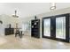 Entryway boasts double glass doors, tiled flooring, a bookshelf, a table with chairs, and a view of the front yard at 4529 Enid Ln, North Port, FL 34288
