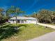 A one-story home with attached garage and a well-manicured front lawn featuring tropical palm trees at 4529 Enid Ln, North Port, FL 34288