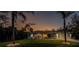 Exterior home shot at dusk features landscaped front yard and concrete driveway with colorful sky backdrop at 4529 Enid Ln, North Port, FL 34288