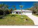 Charming single-story home with well-manicured lawn and a two-car garage, surrounded by lush landscaping at 4529 Enid Ln, North Port, FL 34288