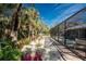 A beautiful view of colorful landscaping and pavers leading up to a screened in pool at 4529 Enid Ln, North Port, FL 34288