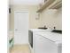 Clean laundry room with a newer front load washer and dryer and shelf storage at 4529 Enid Ln, North Port, FL 34288