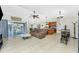 The living room boasts tiled floors, a ceiling fan, a sofa, a coffee table, and flows into the kitchen area at 4529 Enid Ln, North Port, FL 34288