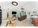 Living room featuring tiled floors, a fan, a sofa, a TV, and a view of the screened-in patio and kitchen area at 4529 Enid Ln, North Port, FL 34288