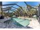 Beautiful backyard pool is enclosed by a screen and surrounded by lush landscaping at 4529 Enid Ln, North Port, FL 34288