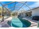 In-ground pool under screened enclosure surrounded by lush tropical landscaping at 4529 Enid Ln, North Port, FL 34288