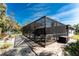 A screened-in pool enclosure sits near lush landscaping and a seating area, offering privacy and a serene escape at 4529 Enid Ln, North Port, FL 34288