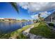 A backyard stone walkway and dock offer serene canal views for relaxing at 494 Monaco Dr, Punta Gorda, FL 33950