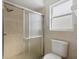 Tiled bathroom featuring a glass shower door and window at 5113 Weatherton St, North Port, FL 34288
