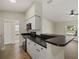 Well-lit kitchen with modern appliances, white cabinetry and sleek black countertops at 5113 Weatherton St, North Port, FL 34288