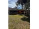 View of the backyard with a screened in patio, lawn, and orange exterior at 5240 Malamin Rd, North Port, FL 34287
