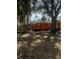 Orange house back exterior with lawn tractor and other items near building at 5240 Malamin Rd, North Port, FL 34287