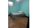 Modest bedroom with aqua walls, laminate wood flooring, and basic furnishings at 5240 Malamin Rd, North Port, FL 34287