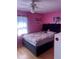 Bright and airy bedroom with vibrant pink walls, a comfortable bed, and a ceiling fan at 5240 Malamin Rd, North Port, FL 34287