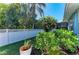Well-manicured backyard with white picket fence and lush tropical landscaping at 621 Trabue Ave, Punta Gorda, FL 33950