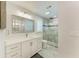 Modern bathroom featuring white cabinets, a decorative mirror, and glass enclosed shower with gray marble tile at 621 Trabue Ave, Punta Gorda, FL 33950
