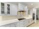 Modern kitchen counter with white cabinetry, white backsplash, stainless steel appliances, and light-colored countertops at 621 Trabue Ave, Punta Gorda, FL 33950