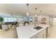 Open concept kitchen with stainless steel sink, quartz counters, pendant lighting, and adjacent living room at 621 Trabue Ave, Punta Gorda, FL 33950