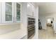 Kitchen wall with white cabinetry, white backsplash, light countertops, and stainless steel wall oven at 621 Trabue Ave, Punta Gorda, FL 33950