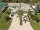 Aerial view of house featuring a well-manicured lawn, mature trees, nice greenery and an oversize driveway at 726 Connemara Ct, Venice, FL 34292