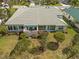 Aerial view of house featuring lush greenery surrounding a well-manicured lawn and a patio at 726 Connemara Ct, Venice, FL 34292