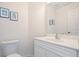 Clean, bright bathroom with a white vanity and blue-framed decorative art at 726 Connemara Ct, Venice, FL 34292