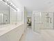Bright bathroom featuring a double vanity, walk-in shower, and separate bathtub, designed for relaxation and convenience at 726 Connemara Ct, Venice, FL 34292