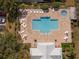 Aerial view of the community pool featuring lounge chairs, tables, and beautifully maintained landscaping at 726 Connemara Ct, Venice, FL 34292