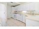 Well-lit kitchen with white cabinetry, modern appliances, and a neutral countertop at 726 Connemara Ct, Venice, FL 34292