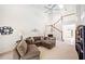 Cozy living room featuring a sectional sofa, a staircase, and abundant natural light at 726 Connemara Ct, Venice, FL 34292