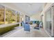 Inviting sunroom with comfortable seating, ceiling fans, and views of the lush backyard and garden at 726 Connemara Ct, Venice, FL 34292