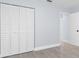 Bright bedroom with a closet with white shutter doors, light gray tiled floors, and white trim at 8326 Fay Ave, North Port, FL 34287