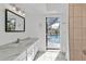 Bright bathroom featuring vanity with marble counter, tile flooring, and a shower with a view to the pool at 20343 Rutherford Ave, Port Charlotte, FL 33952