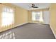 This airy bedroom features a ceiling fan and large windows with sheer curtains at 20343 Rutherford Ave, Port Charlotte, FL 33952