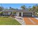 Beautiful single-story home boasts manicured lawn, stone accents, and unique brick-designed driveway at 20343 Rutherford Ave, Port Charlotte, FL 33952