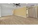 Bright living room with wood-look floors, ceiling fan, neutral walls, and abundant natural light at 20343 Rutherford Ave, Port Charlotte, FL 33952
