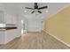 Living room features wood-look floors, neutral walls, ceiling fan and open floor plan leading into the kitchen at 20343 Rutherford Ave, Port Charlotte, FL 33952