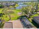 An aerial view of a property with a screened pool, manicured lawn, and golf course and lake views at 1321 Eagles Flight Way, North Port, FL 34287