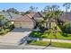 Aerial view of a home with tile roofing, three-car garage, and manicured lawn in a desirable neighborhood at 1321 Eagles Flight Way, North Port, FL 34287