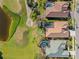 An aerial view of several houses with private pools backing onto a golf course with a scenic lake at 1321 Eagles Flight Way, North Port, FL 34287