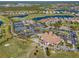 Extensive aerial view of community amenities including golf course, tennis courts, clubhouse, and a sparkling blue pond at 1321 Eagles Flight Way, North Port, FL 34287