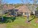 Aerial view of a backyard featuring a screened pool, well-manicured lawn, and mature trees at 1321 Eagles Flight Way, North Port, FL 34287