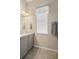 Bathroom featuring a gray vanity, a large mirror and a window with blinds at 1321 Eagles Flight Way, North Port, FL 34287