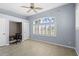 Comfortable bedroom with a ceiling fan, built in desk and a large window with shutters at 1321 Eagles Flight Way, North Port, FL 34287