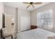 A cozy bedroom with a window, closet, ceiling fan and adjoining hallway at 1321 Eagles Flight Way, North Port, FL 34287