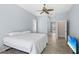 Serene bedroom featuring a ceiling fan, light blue walls, and tile flooring throughout the home at 1321 Eagles Flight Way, North Port, FL 34287