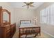 A well lit bedroom that features wood furniture, ceiling fan and a bright window at 1321 Eagles Flight Way, North Port, FL 34287
