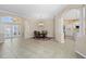 Spacious dining area with tiled floor, columns, chandelier, and entryway with decorative glass doors at 1321 Eagles Flight Way, North Port, FL 34287