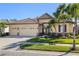 Charming home featuring a three-car garage, tile roof, lush landscaping, and stone accents at 1321 Eagles Flight Way, North Port, FL 34287