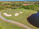 Aerial view of a well-manicured golf course with sand traps and a scenic lake, offering a picturesque recreational setting at 1321 Eagles Flight Way, North Port, FL 34287